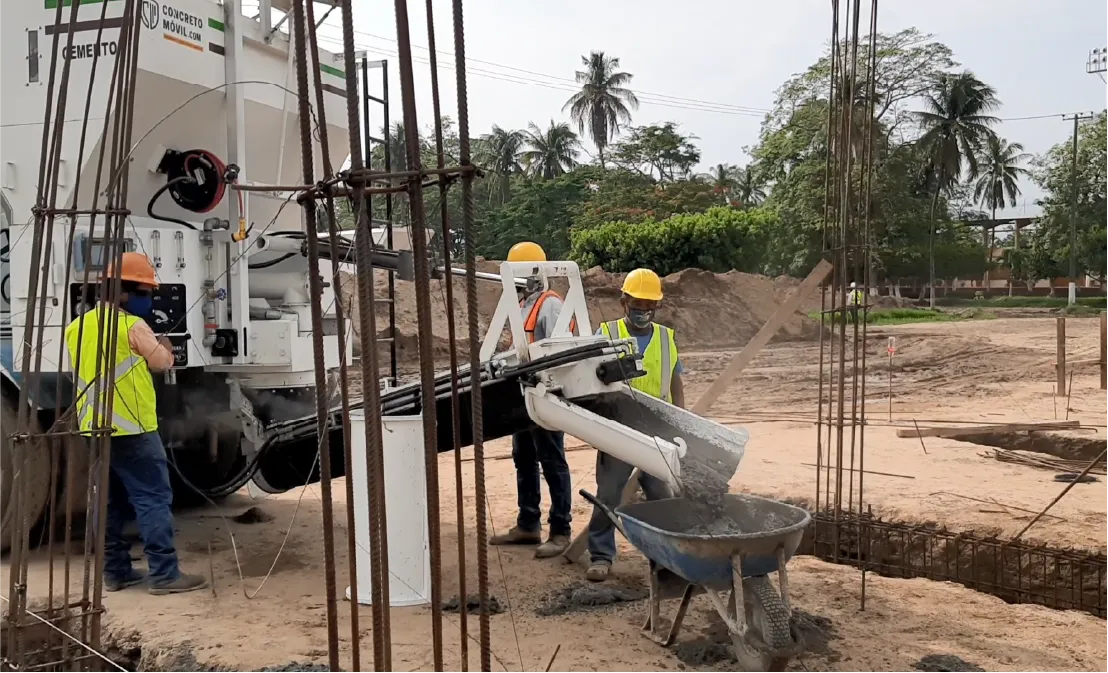 Tres trabajadores utilizando una planta de concreto móvil asegurando mezclas precisas y continuidad laboral.